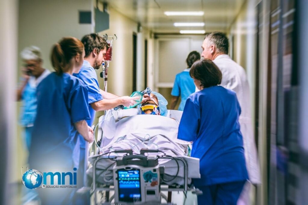 Enfermeiros correndo em hospital com paciente em maca para sala de emergência